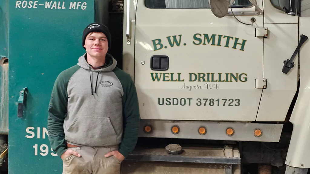 B.W. Smith Well Drilling technician standing beside branded service truck in Augusta, WV